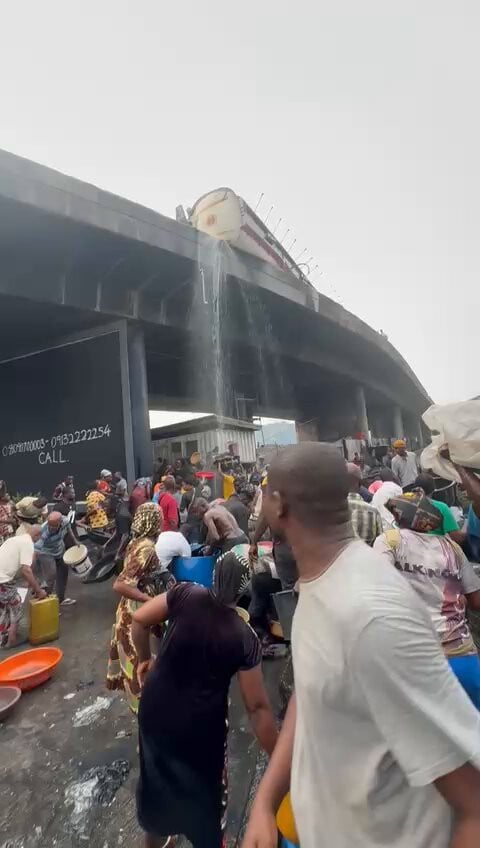 JUST IN: Residents scoop fuel as petrol tanker overturns on Lagos bridge